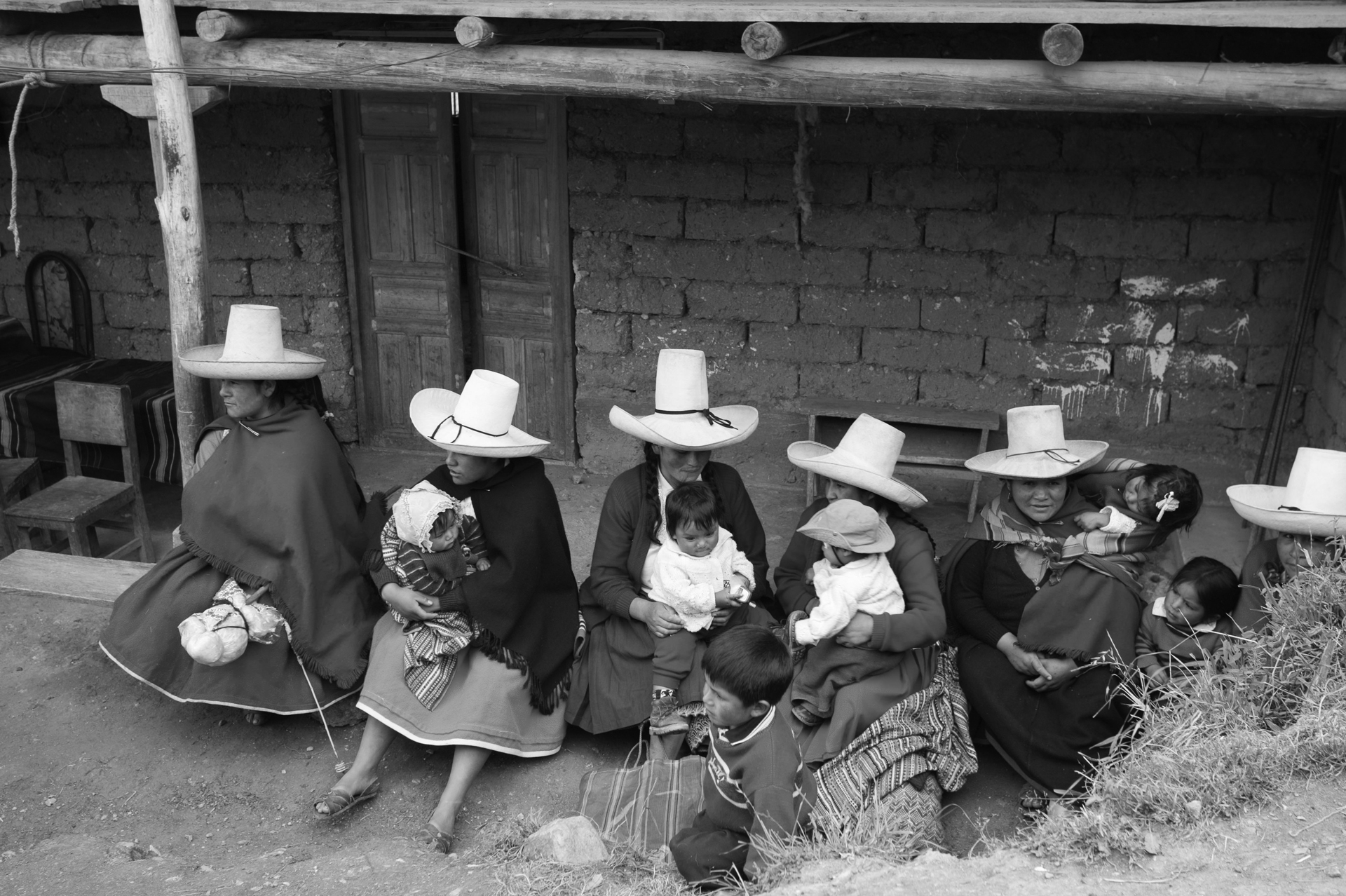 Gathering of women sitting on the front porch of their home, taking care of their babies and small children in a village near Cajamarca,Peru.